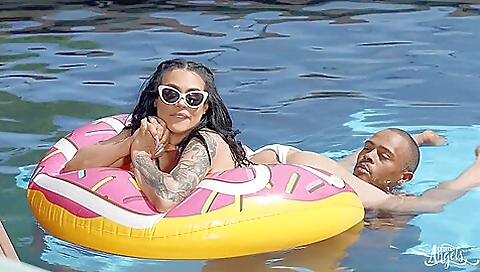 Blonde with small tattoos is on the beach in her jeans